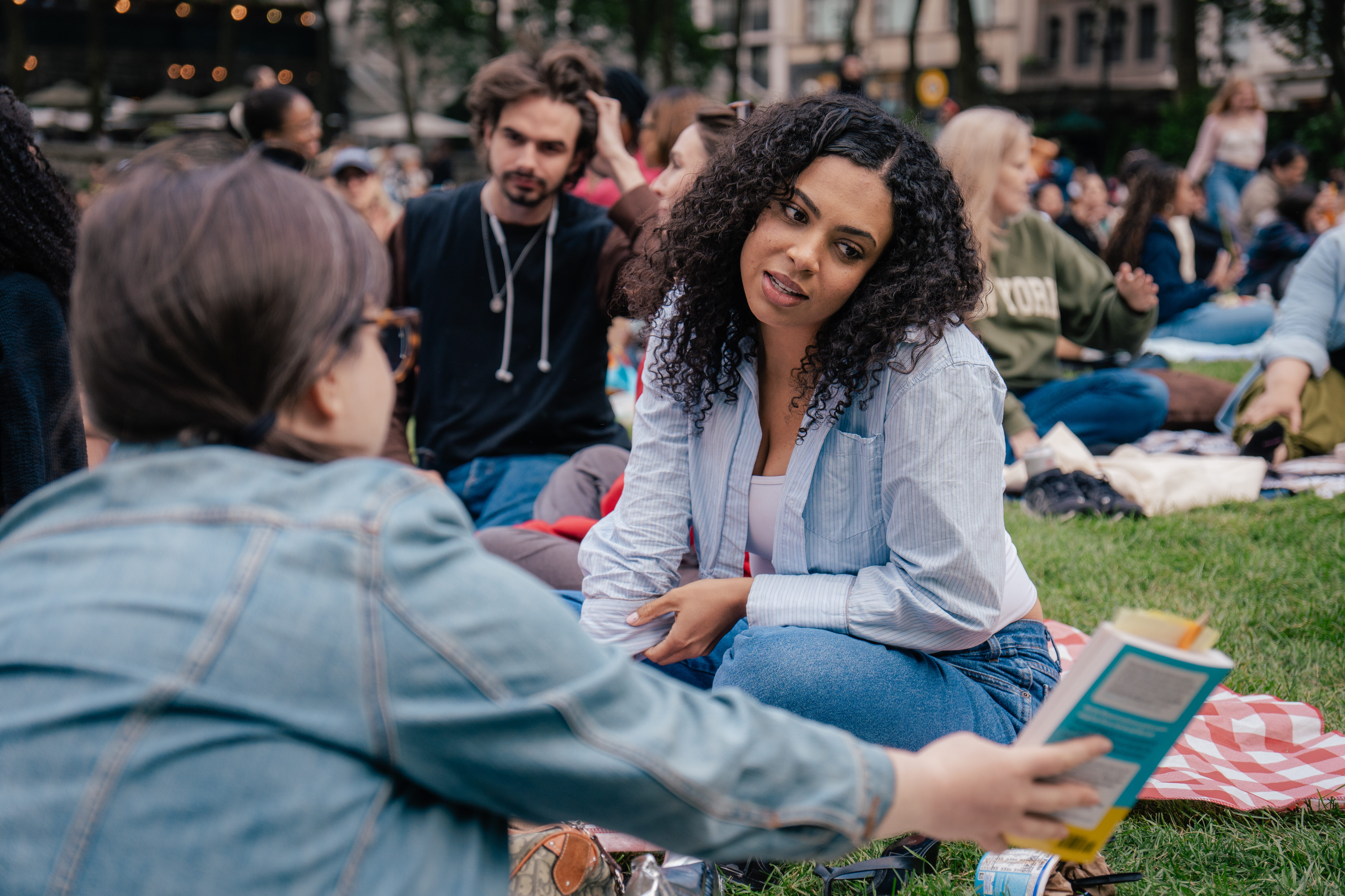 Readers sharing a book in the park